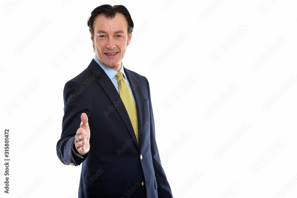 Studio shot of happy mature handsome businessman giving handshake Studio shot of happy mature handsome businessman giving handshake