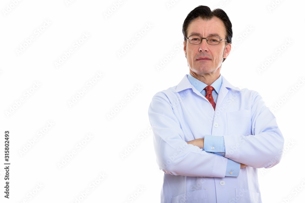 Studio shot of mature handsome man doctor wearing eyeglasses with arms crossed Studio shot of mature handsome man doctor wearing eyeglasses with arms crossed