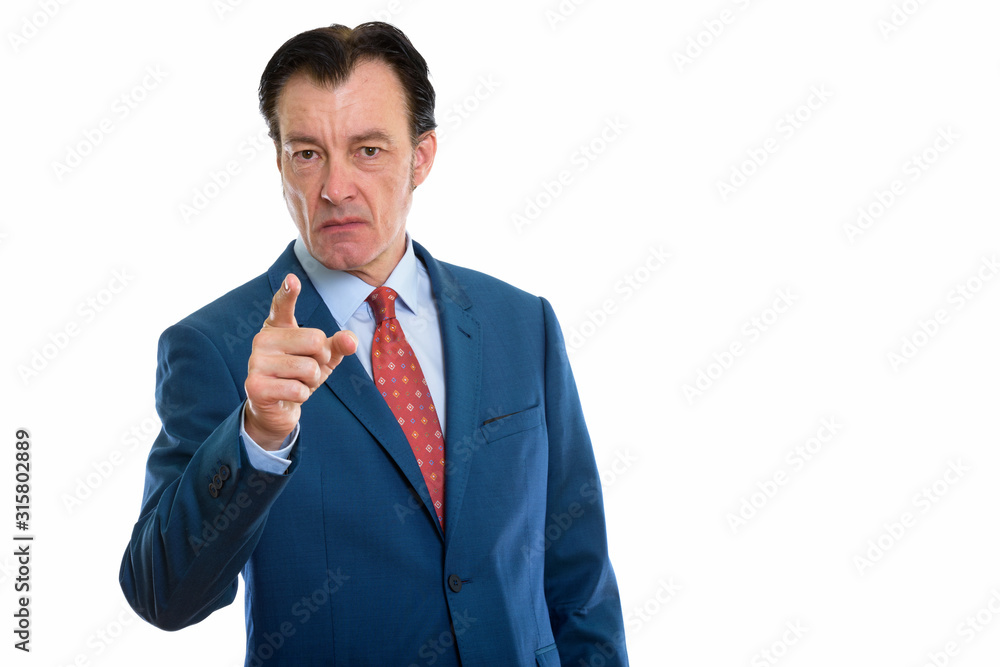 Studio shot of mature angry businessman pointing at camera Studio shot of mature angry businessman pointing at camera