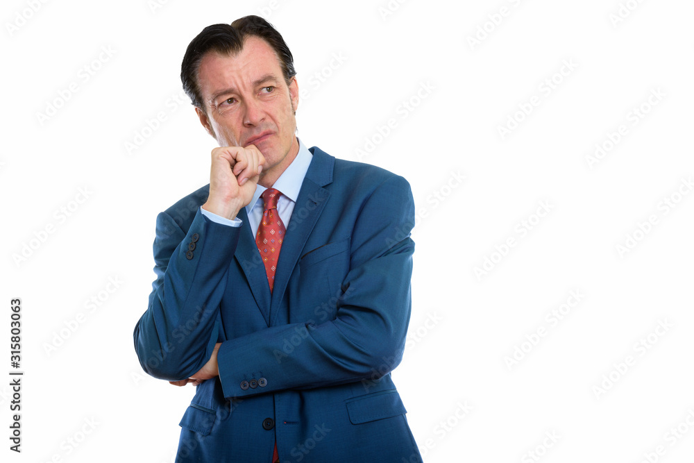 Studio shot of mature angry businessman thinking while looking up Studio shot of mature angry businessman thinking while looking up
