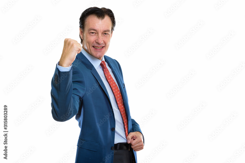 Studio shot of mature happy businessman with fist raised Studio shot of mature happy businessman with fist raised