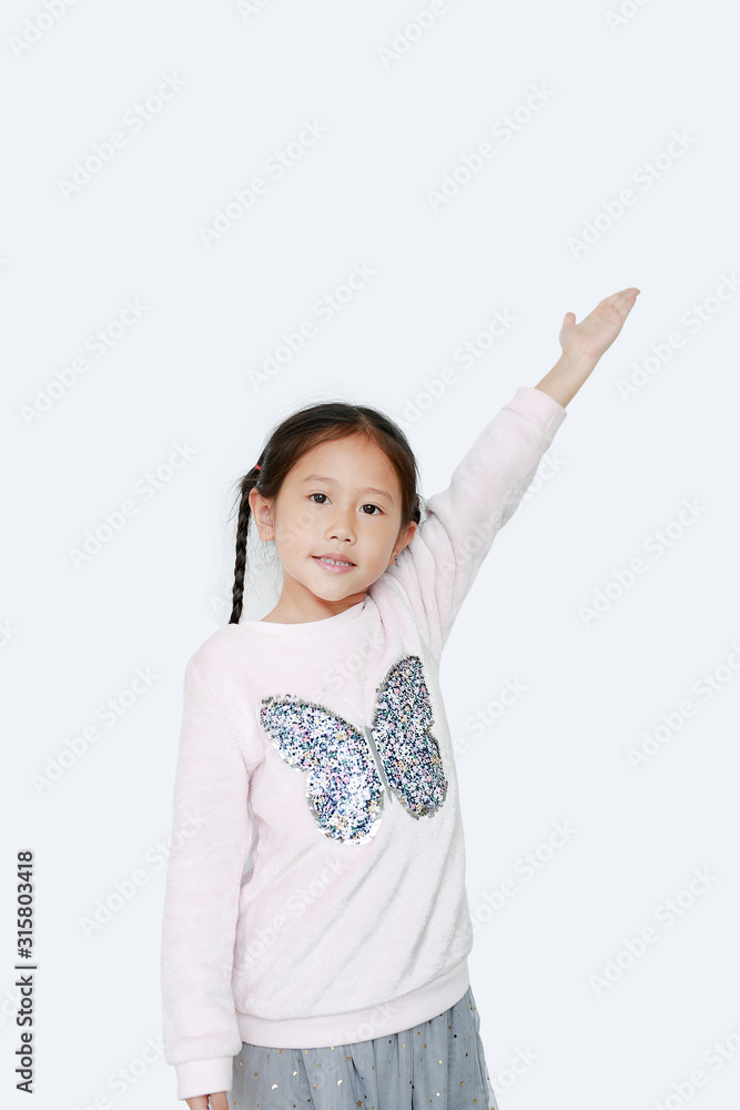Little kid girl standing and points hand up present something on white background. Asian schoolgirl in education concept. Little kid girl standing and points hand up present something on white background. Asian schoolgirl in education concept.