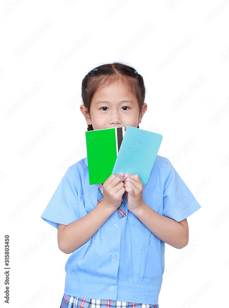 Portrait of Asian little girl in school uniform holding account book isolated on white background. Schoolgirl with bank passbook. Money saving concept. Portrait of Asian little girl in school uniform holding account book isolated on white background. Schoolgirl with bank passbook. Money saving concept.