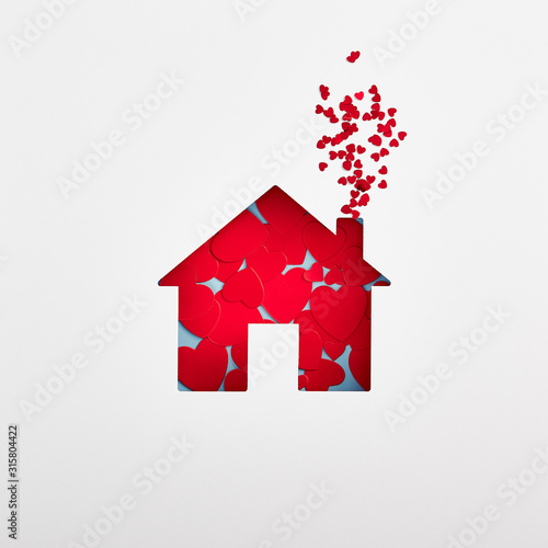 Home silhouette filled with red hearts on white background