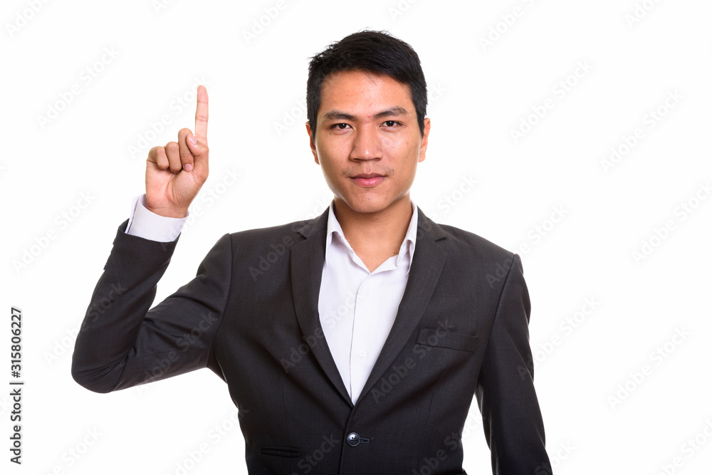 Studio shot of young Asian businessman pointing finger up Studio shot of young Asian businessman pointing finger up