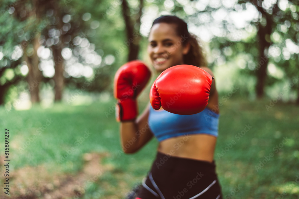 Blurred porty black woman boxer punching to you at park,Female boxer eye looking training to camera,Happy and smiling,Healthy and lifestyle concept Blurred porty black woman boxer punching to you at park,Female boxer eye looking training to camera,Happy and smiling,Healthy and lifestyle concept