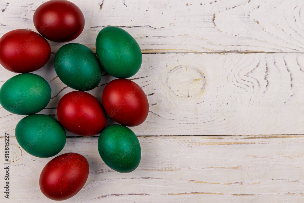 Obraz premium Painted Easter eggs on white wooden background