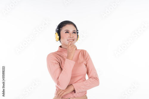 Cheerful Asian teenager wearing turtleneck and pants using wireless headphones enjoying listening to music isolated on white background. Easy to cut out. Landscape orientation.