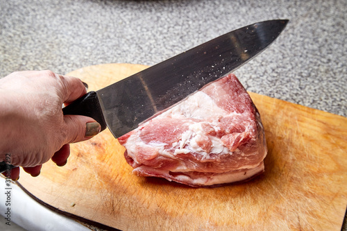 Cooking. A piece of raw meat for cooking on the table on the cutting board with knife