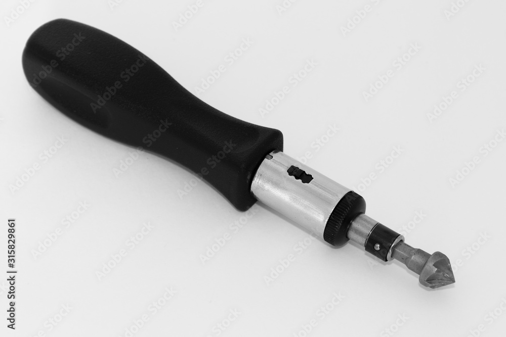 Black handle screwdriver with replaceable countersink bit on white background close up Black handle screwdriver with replaceable countersink bit on white background close up