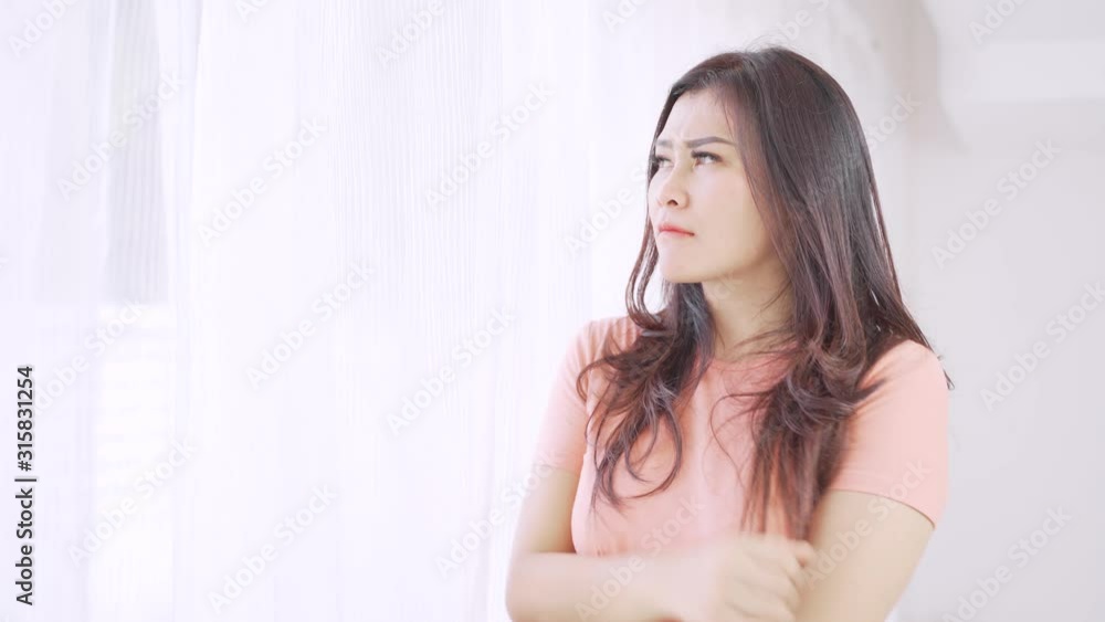Worried pretty woman standing near the window while looking outside. Shot in 4k resolution Worried pretty woman standing near the window while looking outside. Shot in 4k resolution