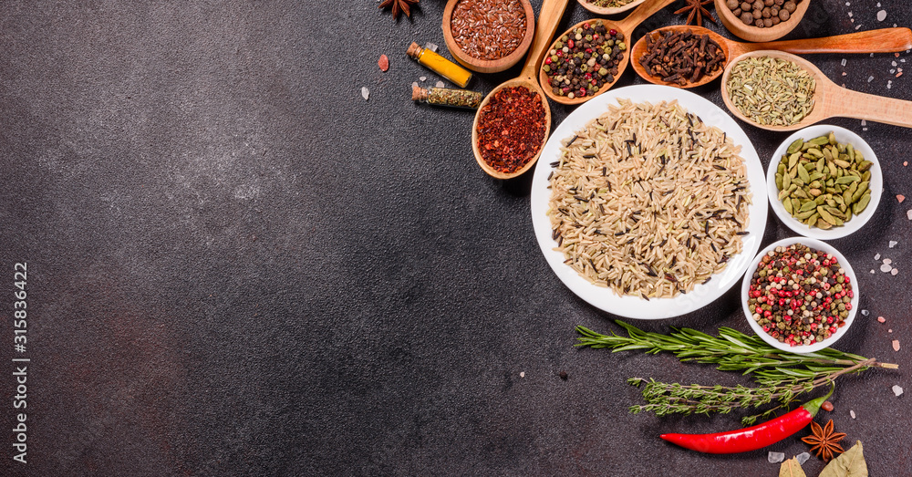 A set of spices and herbs. Indian cuisine. Pepper, salt, paprika, basil and other on a dark background A set of spices and herbs. Indian cuisine. Pepper, salt, paprika, basil and other on a dark background