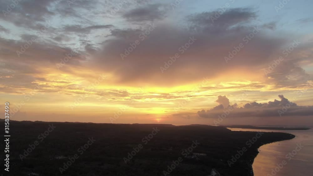 Cinematic 4k aerial video panning right to reveal orange sunset and coast line on Nusa Penida, Indonesia Cinematic 4k aerial video panning right to reveal orange sunset and coast line on Nusa Penida, Indonesia