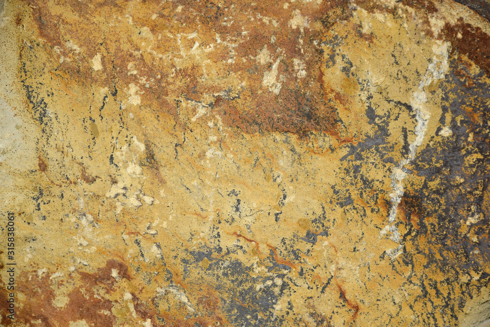Unusual pattern of stone surface, background. Original surface of natural stone in black and brown tones with stains, lines and streaks. Unusual pattern of stone surface, background. Original surface of natural stone in black and brown tones with stains, lines and streaks.