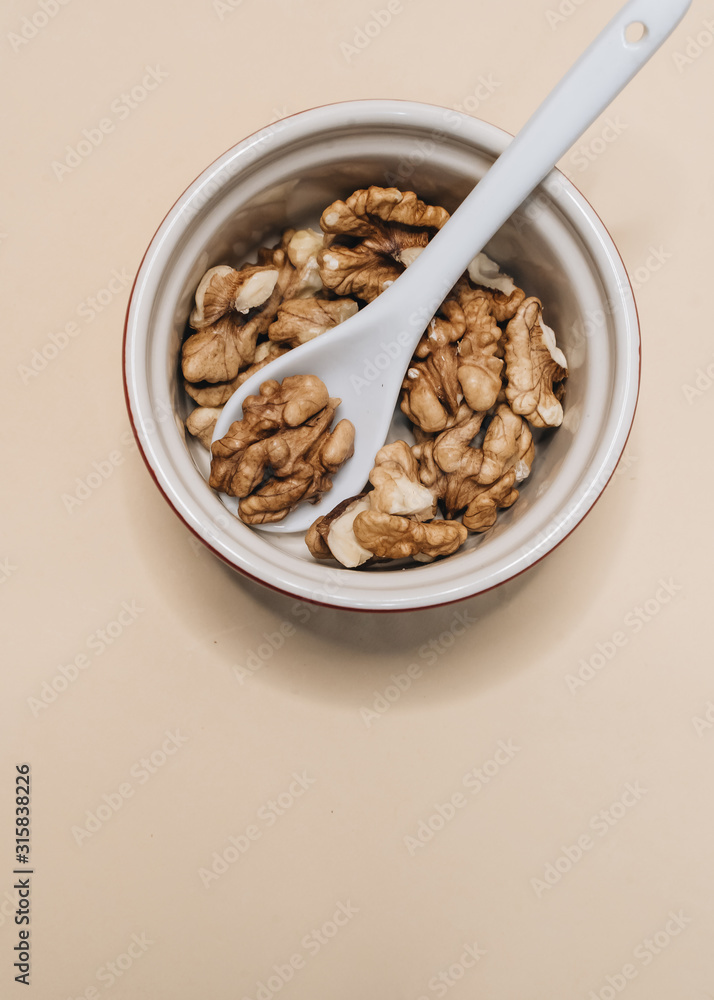 Pile of shelled walnuts in glass bowl, healthy eating concept Pile of shelled walnuts in glass bowl, healthy eating concept