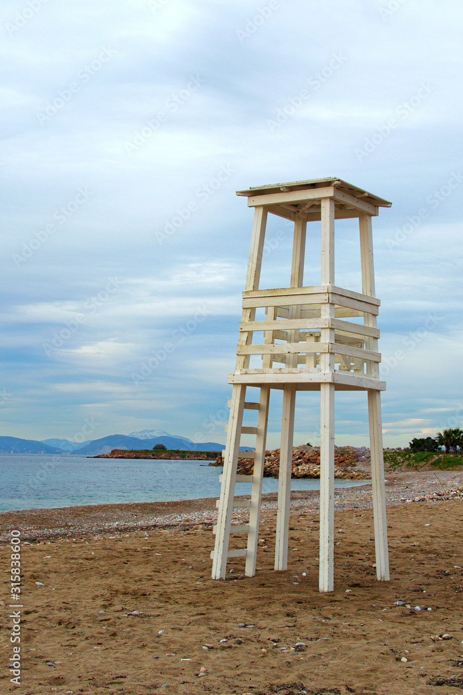 White wooden lifeguard tower on the municipal beach in Glyfada. Winter landscape. Glyfada is a suburb in South Athens located in the Athens Riviera White wooden lifeguard tower on the municipal beach in Glyfada. Winter landscape. Glyfada is a suburb in South Athens located in the Athens Riviera