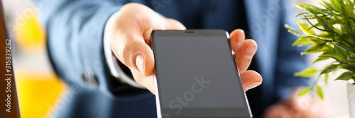 Male arm in suit show in camera phone display screen closeup. Read news mania send sms chat addict use electronic bank modern lifestyle job plan colleague share blog tweet web application search