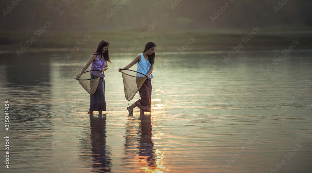 Fototapeta premium Women fisherman casting fish in the lake ,Thailand
