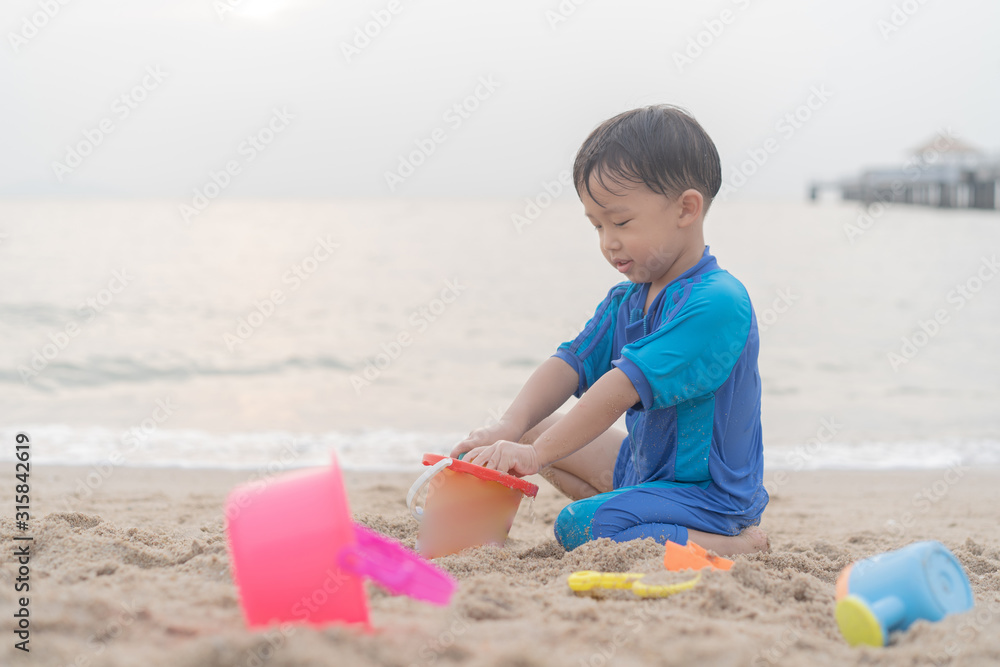 A boy is playing sand and swimming with his brother on the beach. A boy is playing sand and swimming with his brother on the beach.