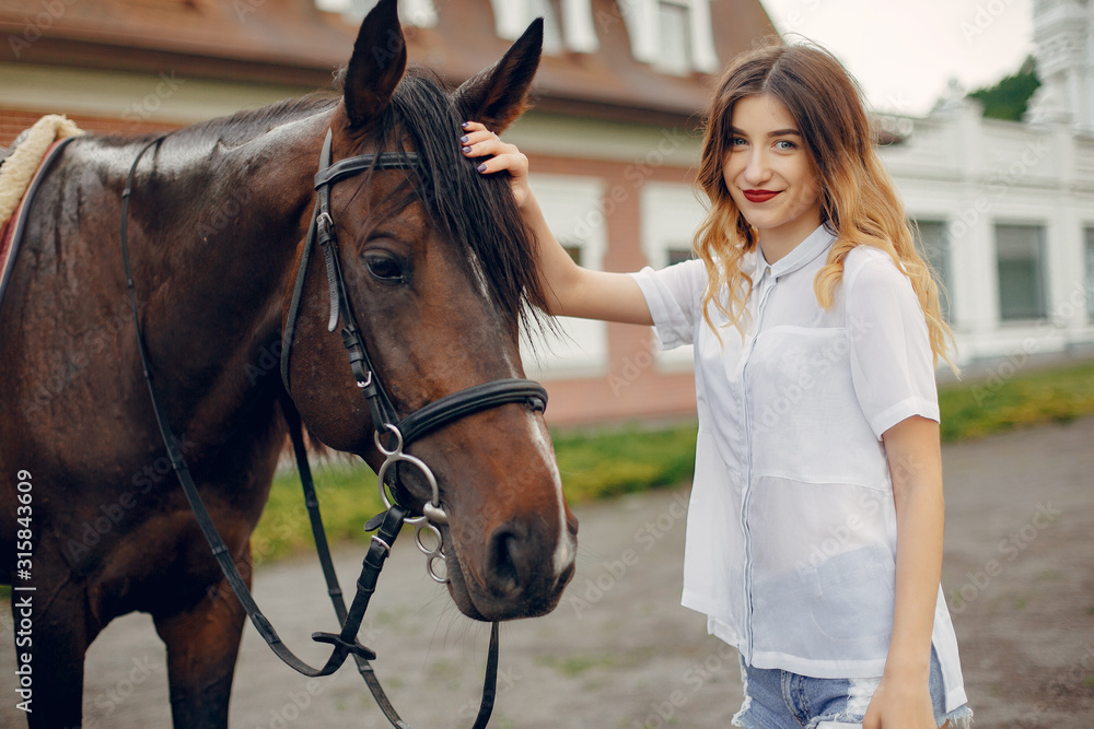 Fototapeta premium Woman standing with a horse. Lady in a white shirt