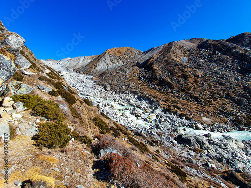 Everest base camp trek itinerary: from Machhermo to Gokyo. Beautiful views of autumn hills, snowy mountains and turquoise water of Dudh Koshi river. photo