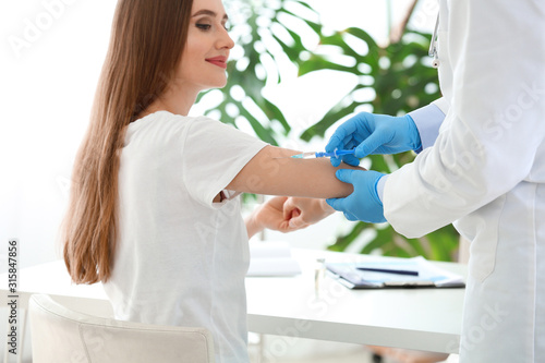 Doctor vaccinating young wo...