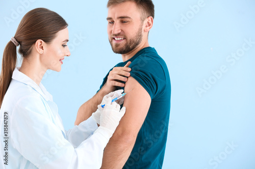 Doctor vaccinating young ma...