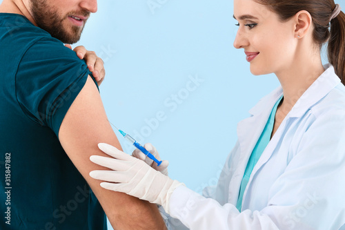 Doctor vaccinating young ma...