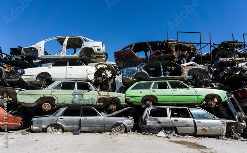 Old damaged cars on the junkyard waiting for recycling