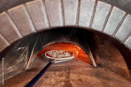 Canvastavla Baked tasty margherita pizza in Traditional wood oven in Naples restaurant, Italy