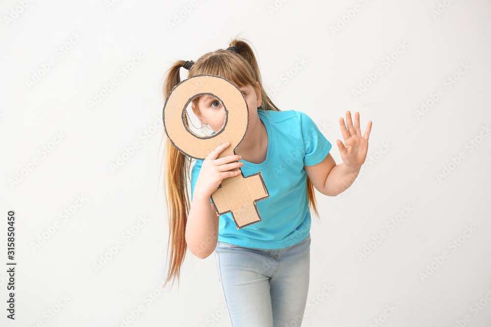 Fototapeta premium Little girl with symbol of woman on light background. Concept of feminism