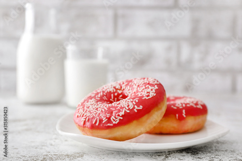 Plate with sweet tasty donuts on table