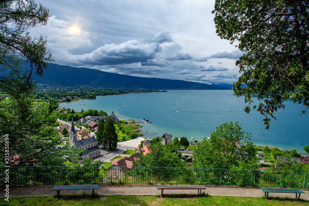 view of lake of Annecy and Duingt village with cloudy sky, french Alps