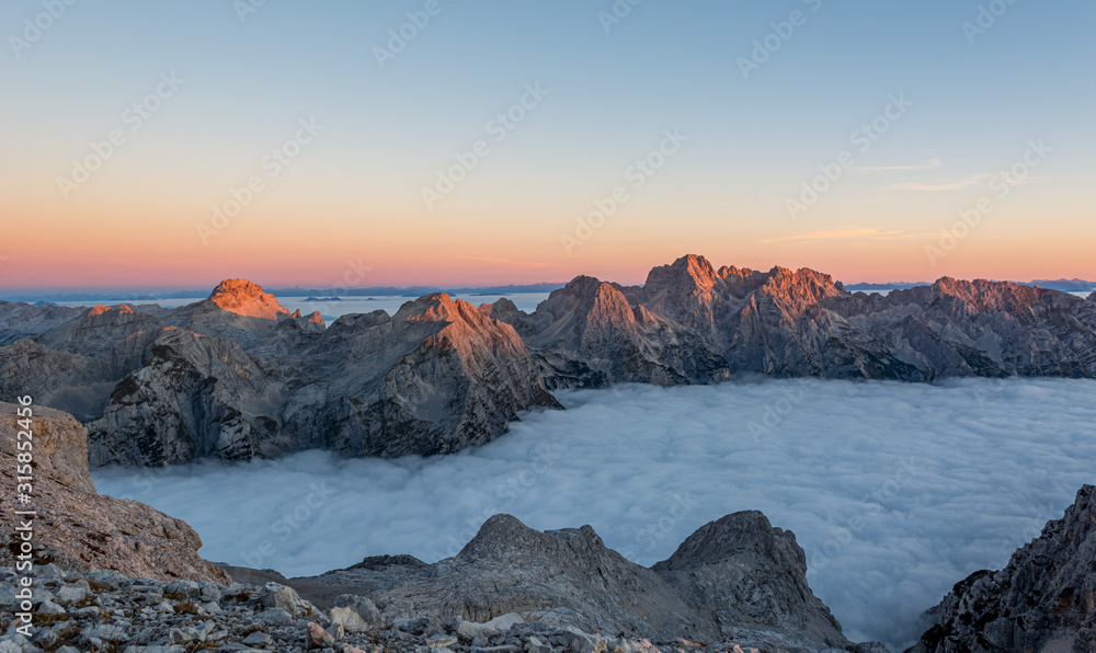 Spectacular morning mountain panorama with mists covering a valley.