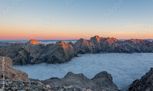Spectacular morning mountain panorama with mists covering a valley. © anzebizjan