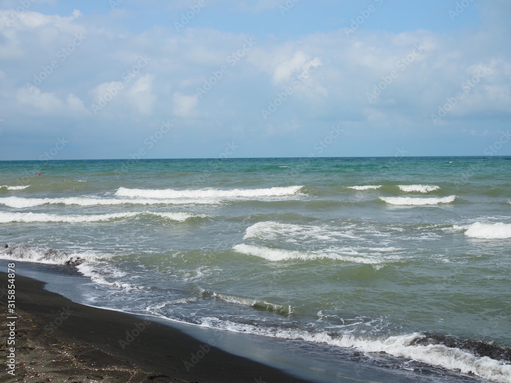 beautiful waves in the sea and black sand