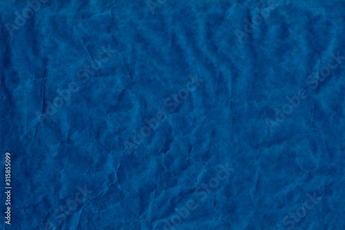 Empty blue sheet brown crumpled wrapping or parchment paper. Texture or background. Space for design or text. Soft focus. Top view.