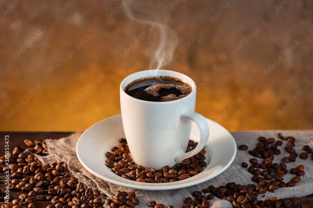 White coffee cup and coffee beans on wooden background White coffee cup and coffee beans on wooden background