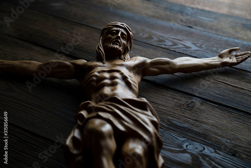 Canvas Print Cruciefied Jesus figure isolated on rustic dark brown table.