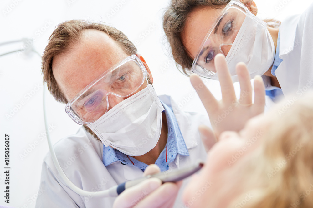 Dentist and medical assistant at the caries treatment