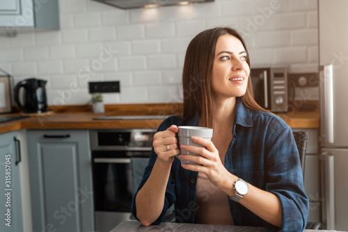 Girl in a shirt with coffee in hand.