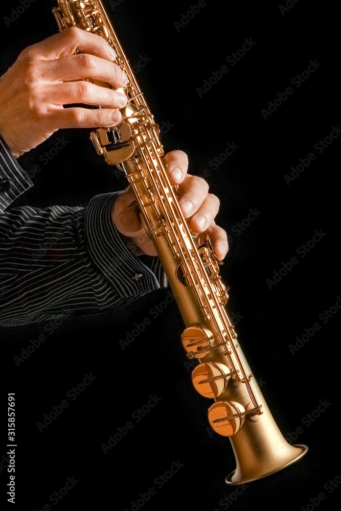 Obraz premium soprano saxophone in hands on a black background