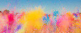Crowd throwing bright colored powder paint in the air at Holi Festival Dahan