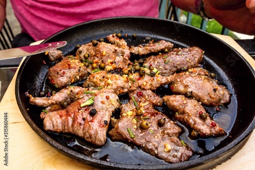 Spicy pork steaks on pan.