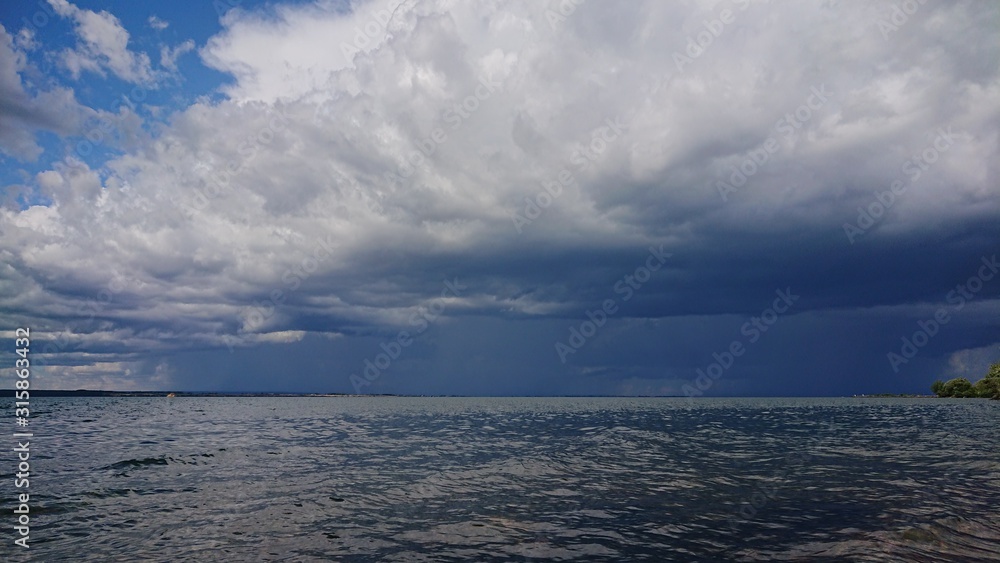 Obraz premium Dramatic thunderstorm clouds forming over a lake