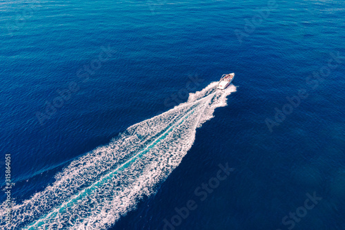 Top view of the sea and a high-speed white boat on a Sunny day. Concept of summer vacation at the sea. Beautiful seascape in summer