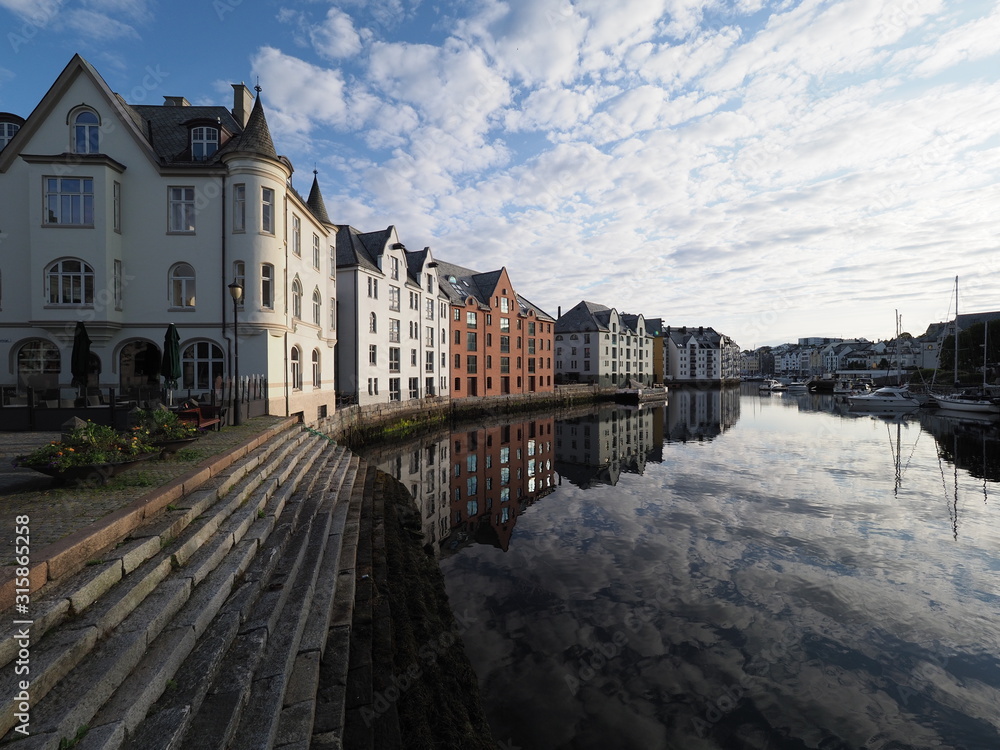 Colored secessionist buildings reflected in water in european Alesund town at Romsdal region in Norway - obrazy, fototapety, plakaty 