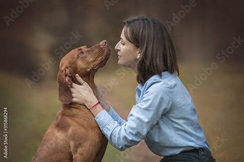 Happy young woman hugging a dog.