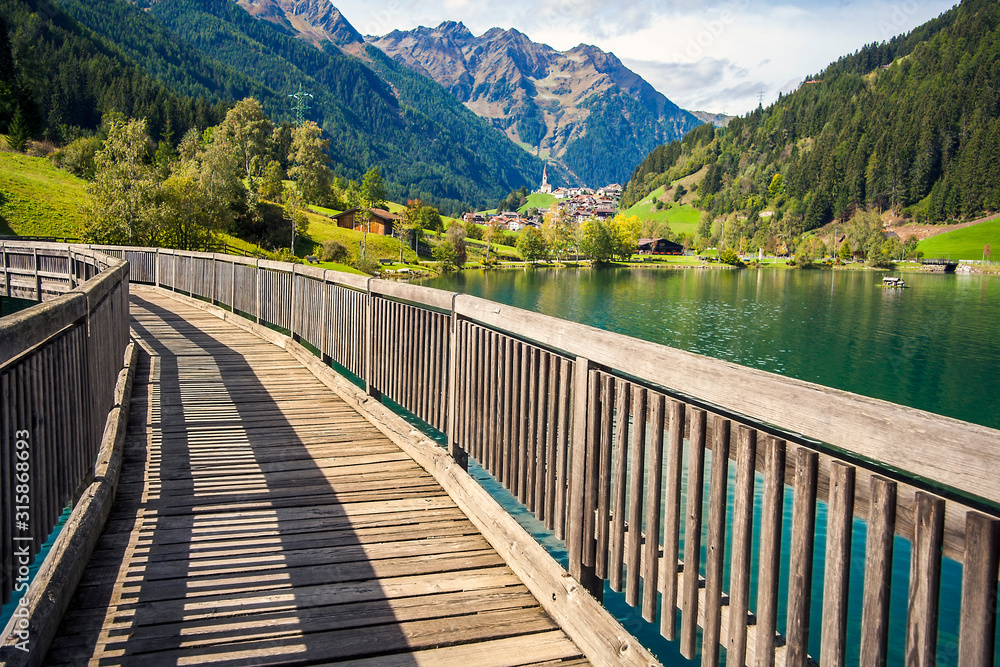 Wooden bridge over the Mühlwald reservoir in Mühlwald South Tyrol Italy