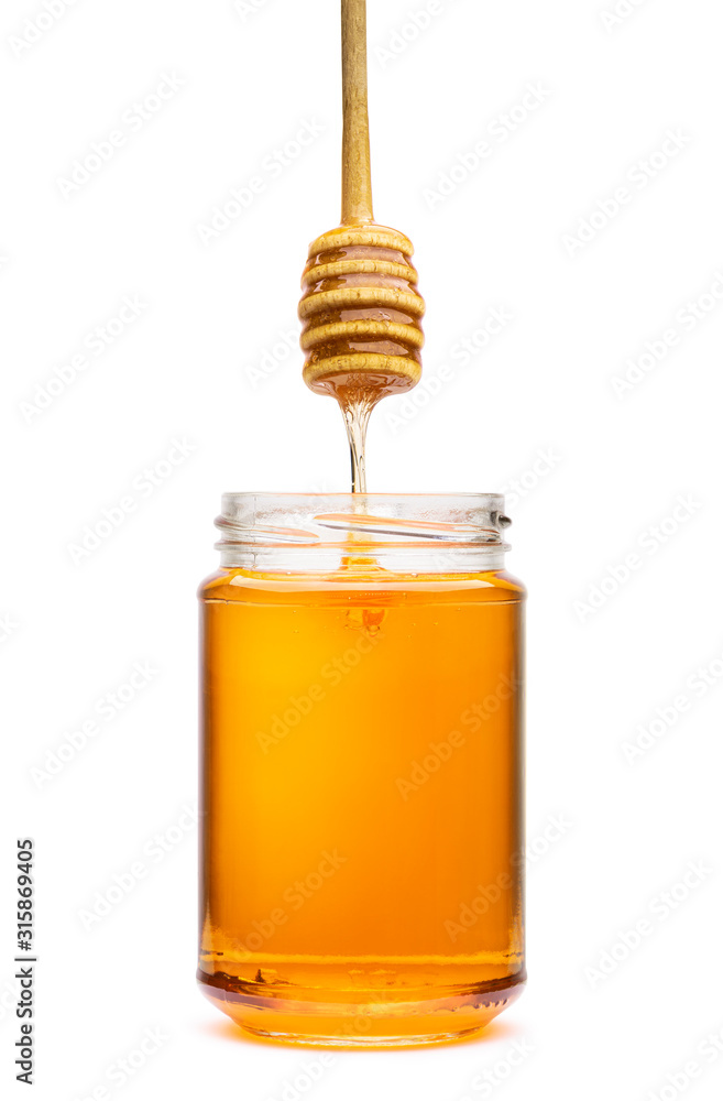 Honey wooden dripper above glass jar, on white background Honey wooden dripper above glass jar, on white background